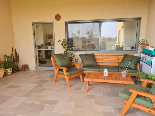 sala de estar con sofá, sillas y mesa en פינה קסומה בגליל, en Dafna