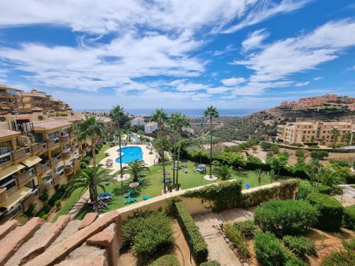 een uitzicht op een resort met een zwembad en palmbomen bij Sunny Coast in Sitio de Calahonda