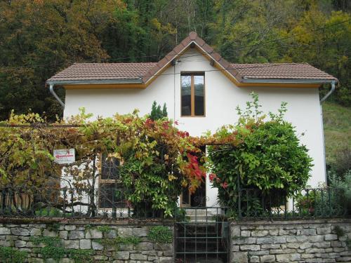 a small white house behind a stone fence at la quatorze in Baume-les-Dames