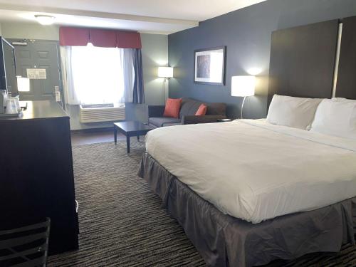 a hotel room with a large bed and a couch at Best Western University Inn at Valparaiso in Valparaiso
