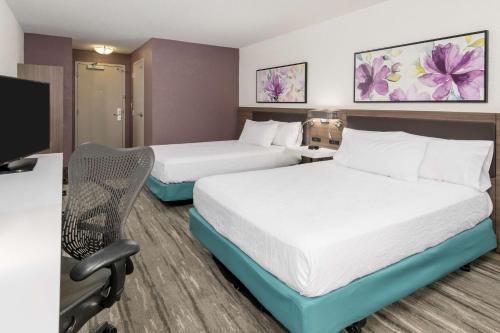 a hotel room with two beds and a desk at Hilton Garden Inn Lafayette/Cajundome in Lafayette