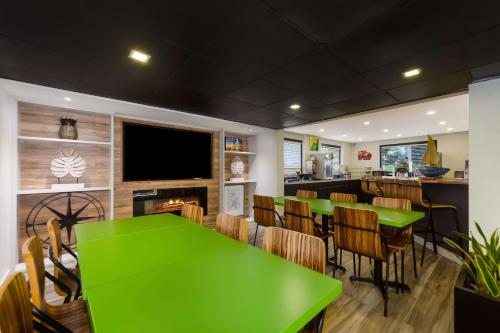 a dining room with a green table and chairs at Quality Inn Coliseum in Charleston