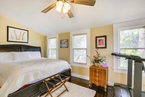 a bedroom with a bed and a fan and windows at Central Albany Home with Covered Porch and Patio! in Albany