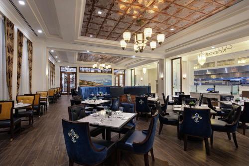 a restaurant with tables and chairs in a room at Higgins Hotel, Official Hotel of The National WWII Museum, Curio Collection by Hilton in New Orleans