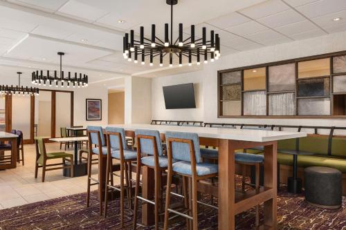 a restaurant with a bar with chairs and a chandelier at Hampton Inn Stockton, Ca in Stockton