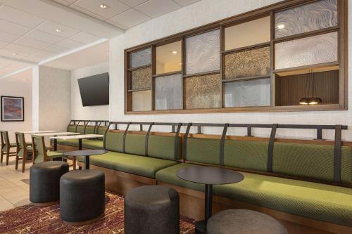 a waiting room with green seats and tables and windows at Hampton Inn Stockton, Ca in Stockton