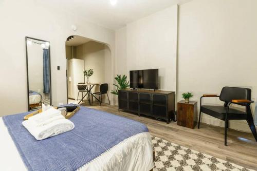 1 dormitorio con 1 cama azul y TV en Lovely Studio Apt in NYC!, en Nueva York