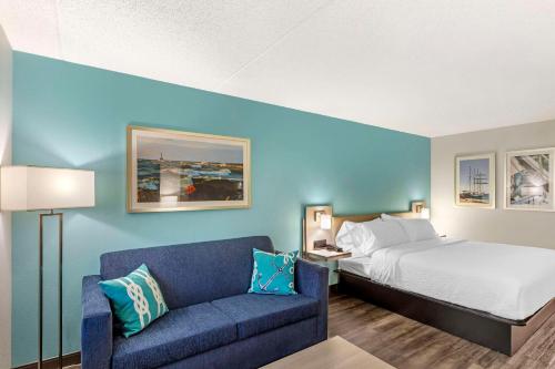 a hotel room with a bed and a couch at The Harborview, Ascend Hotel Collection in Port Washington