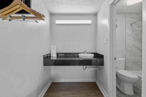 a bathroom with a sink and a toilet at Budget Inn-Norfolk, VA - Oceanview in Norfolk