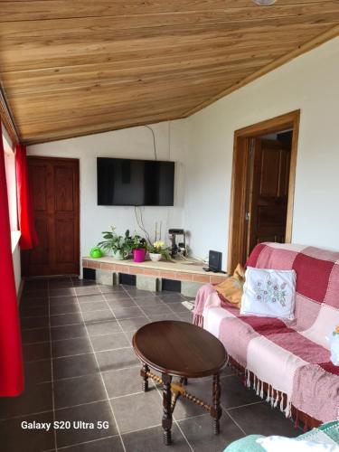 a living room with a couch and a flat screen tv at AP Luso Brasileiro in Lajes das Flores