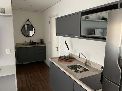 eine Küche mit einer Spüle und einer Arbeitsplatte in der Unterkunft Studio Aconchegante in São Paulo