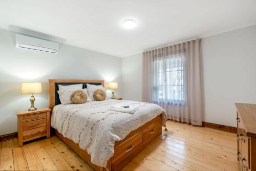 Un dormitorio con una cama grande y una ventana en Welcoming Ambiant 3BR Abode, en Tanunda