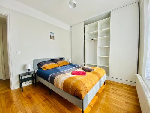 - une chambre dotée d'un lit avec des draps orange et bleu dans l'établissement Cozy Appart'3 - Centre ville & Proche Gare - Cozy Houses, à Massy