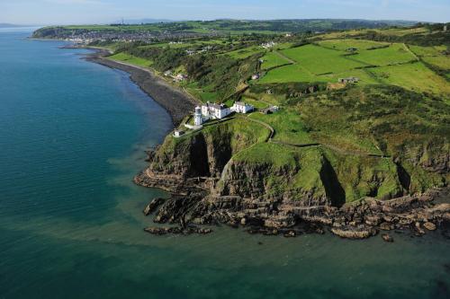 an aerial view of a rocky island in the ocean at The King's Parlour Whitehead in Whitehead