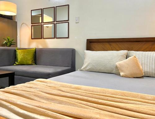 um quarto com uma cama e um sofá em Bea’s Transient (Condo Studio Room for 2!) em Manila