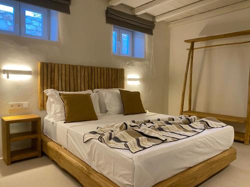 a bedroom with a large bed with a wooden headboard at Nerea Sunset View Apartment in Agia Irini Paros