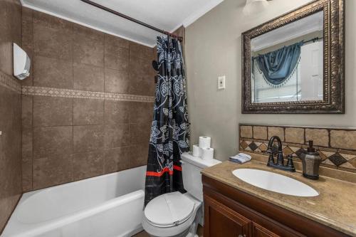 a bathroom with a sink and a toilet and a tub at Dazzling Centrally Located Ocean View w Huge Private Yard, 2 Decks, Firepit, BBQ in Myrtle Beach