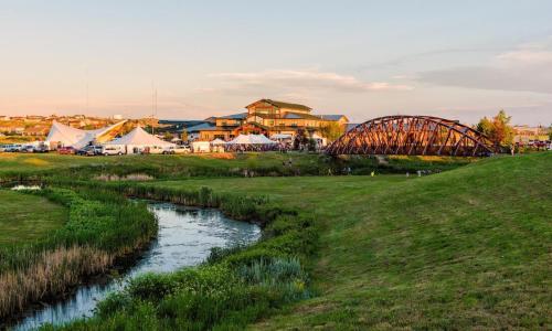 a river in a field with a bridge and tents at Holiday Inn Express Hotel & Suites Gillette by IHG in Gillette