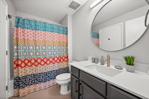 ein Badezimmer mit einem Waschbecken, einem WC und einem Spiegel in der Unterkunft Charming Downtown Getaway in Salt Lake City