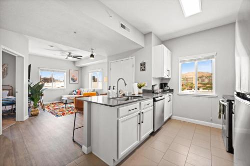 a kitchen with white cabinets and a living room at Central City Escape in Salt Lake City