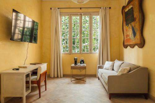 a living room with a couch and a table and a window at Maison du comte in Mexico City