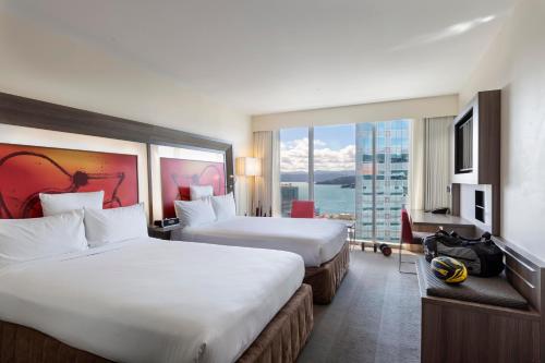 a hotel room with two beds and a large window at Novotel Wellington in Wellington