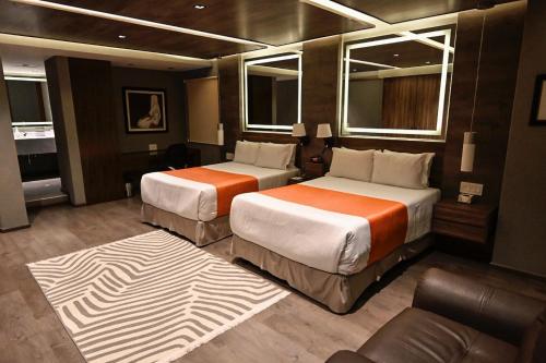 Habitación de hotel con 2 camas y sofá en Hotel Park Nilo Reforma, en Ciudad de México