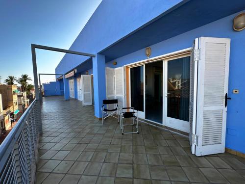 a blue building with a balcony with a chair at Loft a Pasos del Puerto y Playa en Lo Pagán in Lo Pagán