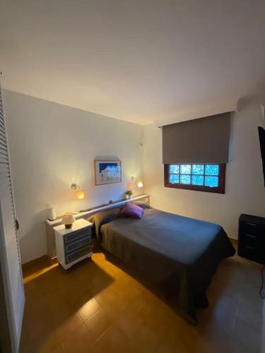 a bedroom with a large bed and a window at Bungalow con jardín y piscina in San Bartolomé de Tirajana