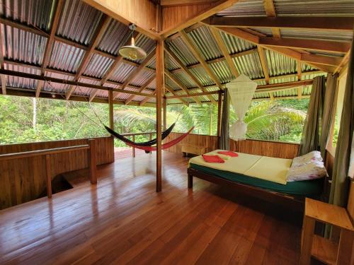 a room with a hammock in a tree house at Corcovado Guest House in Drake