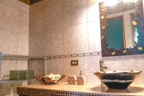 een badkamer met een wastafel en een grote spiegel bij Hummingbird House Panama in Los Altos de Cerro Azul