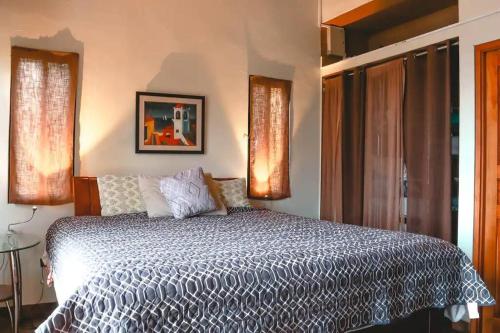 een slaapkamer met een bed met een blauw en wit dekbed bij Hummingbird House Panama in Los Altos de Cerro Azul
