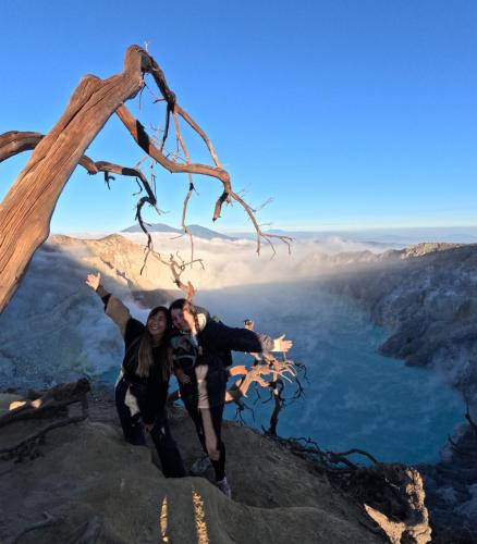 two people standing on the edge of a mountain at Ijen Transito 2 HOMESTAY in Ketapang