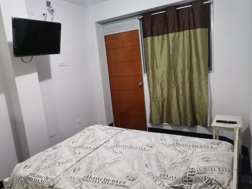 1 dormitorio con 1 cama y TV de pantalla plana en Hotel JK en Pucallpa