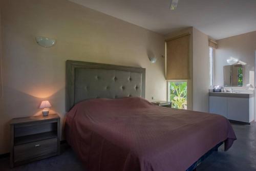 a bedroom with a bed and a lamp on a night stand at Marysol beachfront next to nomads d2 in Isla Mujeres