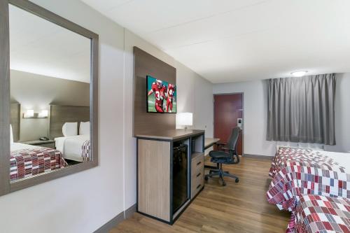 a hotel room with two beds and a mirror at Red Roof Inn Baltimore in Baltimore