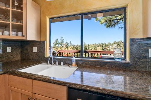 een keuken met een wastafel en een groot raam bij King's Cabin - Spacious mountain home with picturesque views, fast internet! in Big Bear Lake