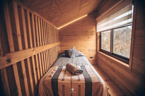 ein kleines Zimmer mit einem Bett in einer Holzhütte in der Unterkunft Yuki Yama in Malalcahuello