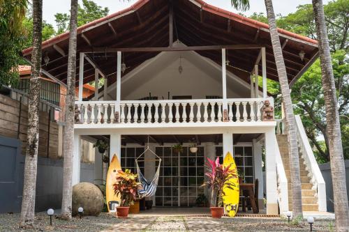 a house with two surfboards in front of it at Mai Ke Kai Surf House in Tamarindo