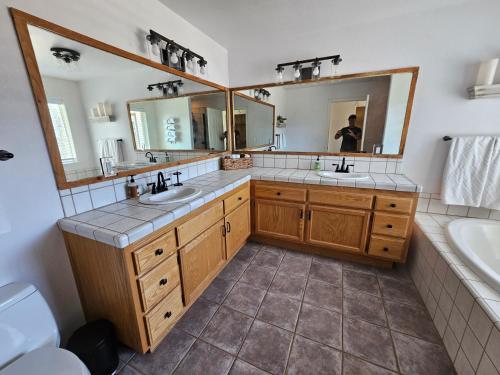 a bathroom with two sinks and two mirrors at Hidden Falls Retreat in Oakhurst