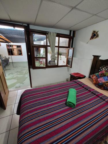 Un dormitorio con una cama con una almohada verde. en Francisco's rest house hotel en Antigua Guatemala
