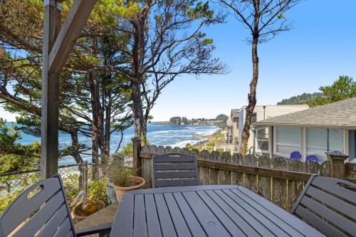 a table and chairs on a porch with a view of the water at Whale Vista in Depoe Bay