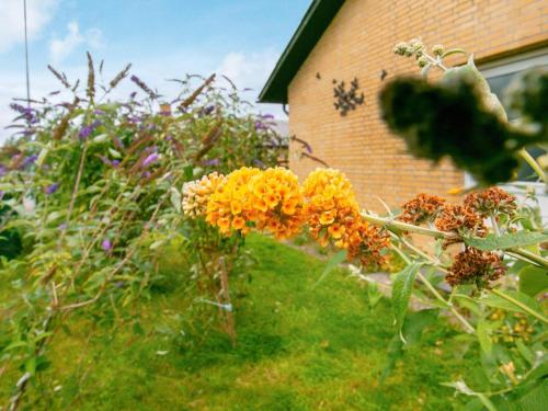 un ramo de flores en la hierba al lado de un edificio en 6 person holiday home in Tranek r, en Tranekær