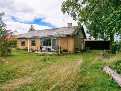 una pequeña casa en un campo con un patio en 6 person holiday home in Tranek r, en Tranekær