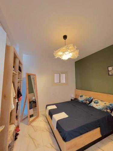 1 dormitorio con cama y pared verde en SHARM ENJOY APARTMENTS en Sharm El Sheikh