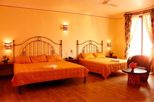 um quarto com 2 camas com lençóis laranja em Hotel Danibaan em Oaxaca de Juárez