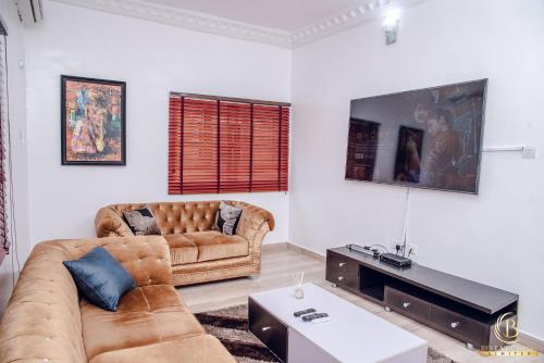 a living room with a couch and a tv at BEST VGC SUITE LTD in Aja