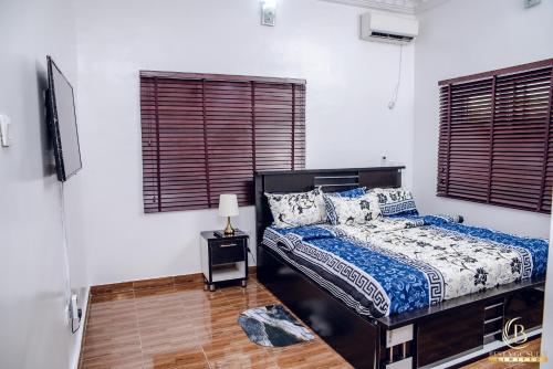 a bedroom with a bed and two windows at BEST VGC SUITE LTD in Aja