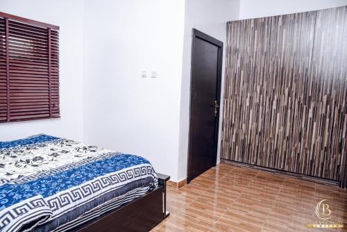 a bedroom with a bed and a wooden floor at BEST VGC SUITE LTD in Aja