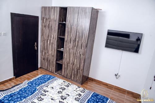 a room with a book shelf and a tv on a wall at BEST VGC SUITE LTD in Aja